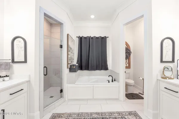 a bathroom with a double vanity sink mirror and bathtub