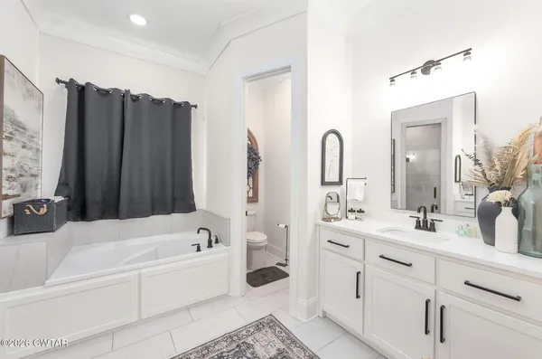 a bathroom with a double vanity sink mirror double and bathtub