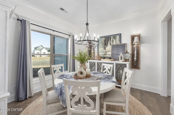 a dining room with furniture a chandelier and wooden floor