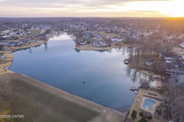 a view of a house with a yard and large tree