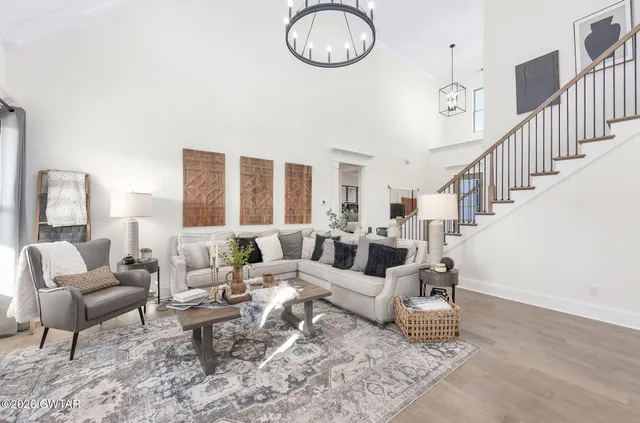 a kitchen with stainless steel appliances kitchen island granite countertop a refrigerator a stove a sink a dining table and chairs with wooden floor