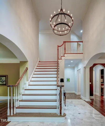 a kitchen with stainless steel appliances kitchen island granite countertop a stove a sink a refrigerator a dining table chairs and white cabinets