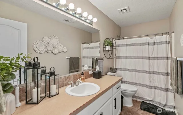 a bathroom with a double vanity sink mirror and toilet