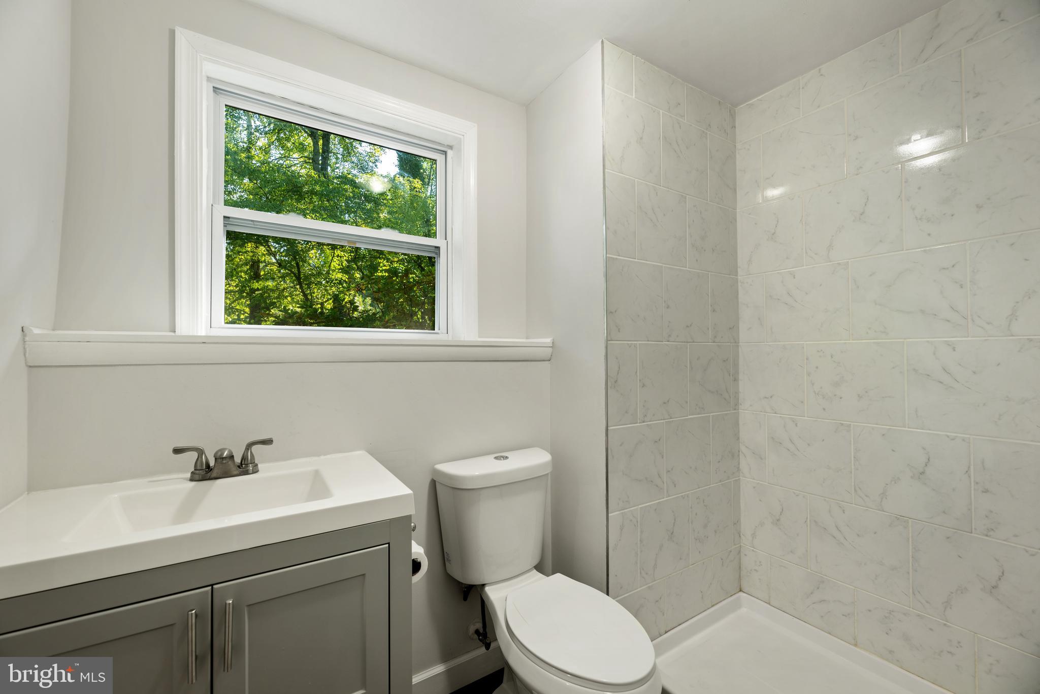 5756 Stephen Reid Road Huntingtown, MD 20639 - Photo 36 of 42 a bathroom with a sink a toilet and a window