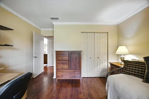 a view of a bedroom with wooden floor and window