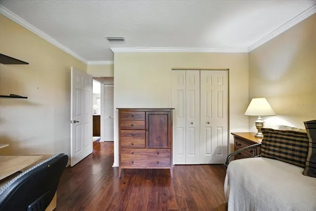 a view of a bedroom with wooden floor and window