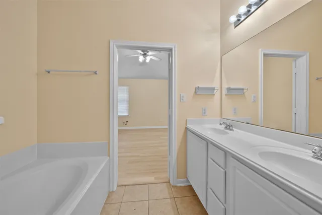 a bathroom with a tub sink and mirror