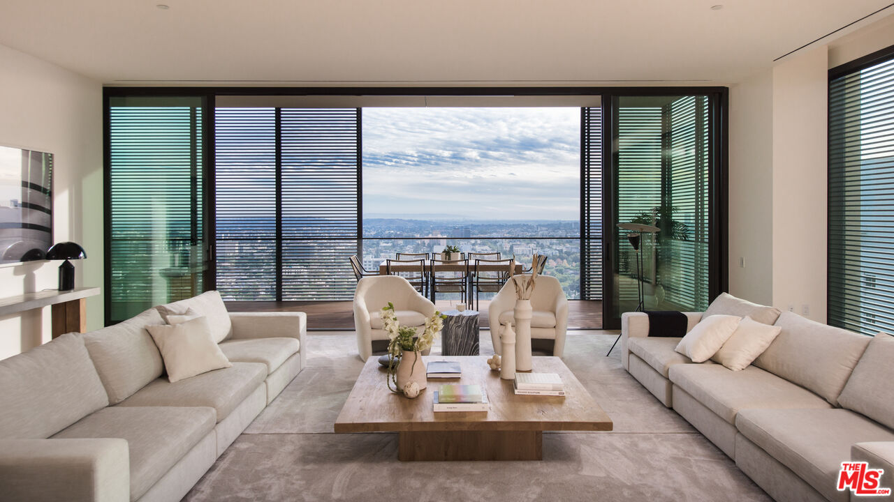 9040 Sunset Boulevard, Unit PHA West Hollywood, CA 90069 - Photo 6 of 30 a living room with furniture large windows and a flat screen tv