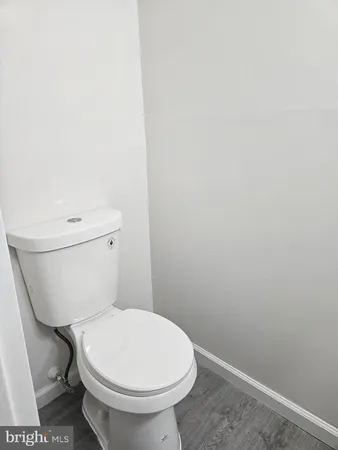 a white toilet sitting next to a white wall