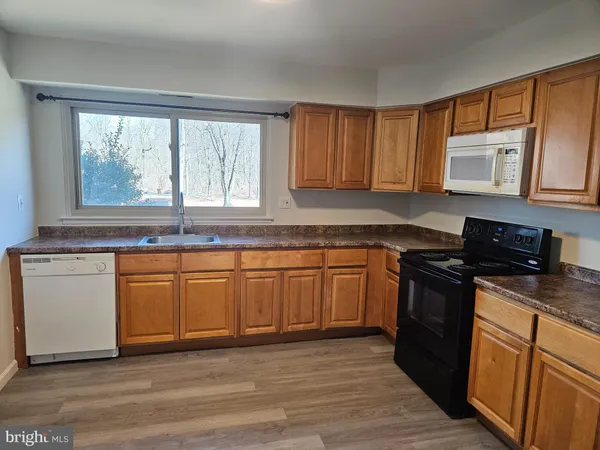 a kitchen with granite countertop wooden cabinets a sink and a stove