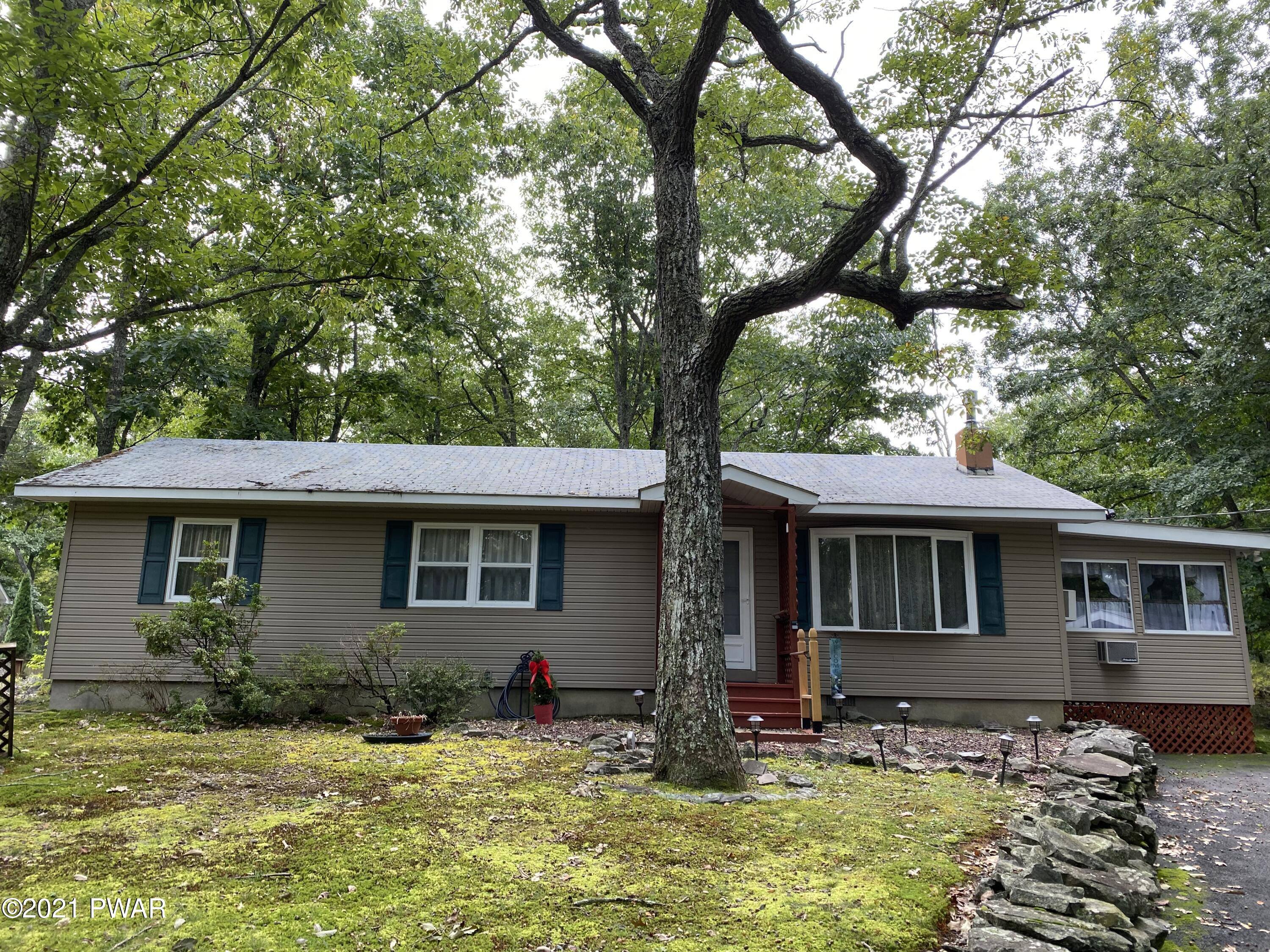 a front view of a house with yard tub and trees