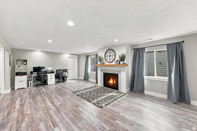 615 West 1870th Street South Payson, UT 84651 - Photo 12 of 31 Spacious room featuring wood-finish flooring, recessed lighting, and a white brick fireplace with a wood mantle