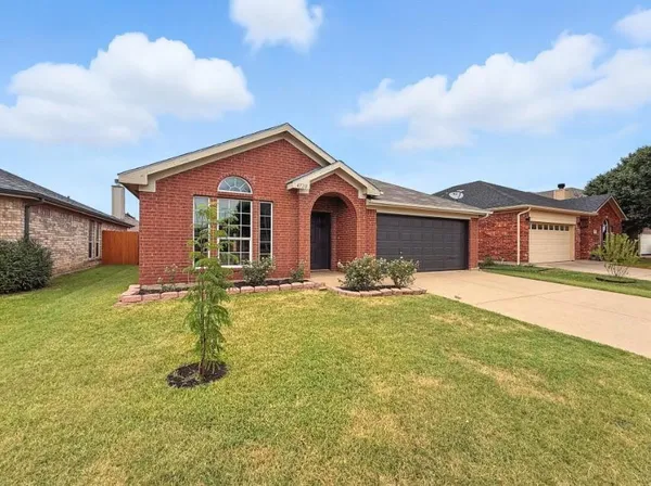 a front view of a house with yard and green space