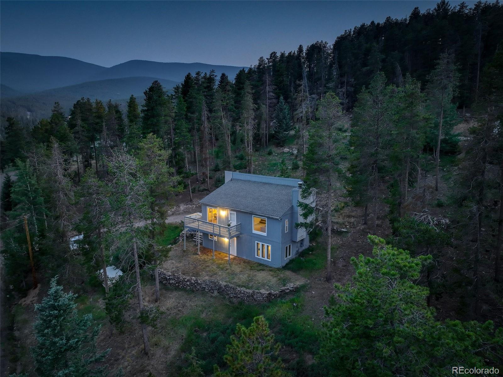 a view of a big house with a yard and mountain view