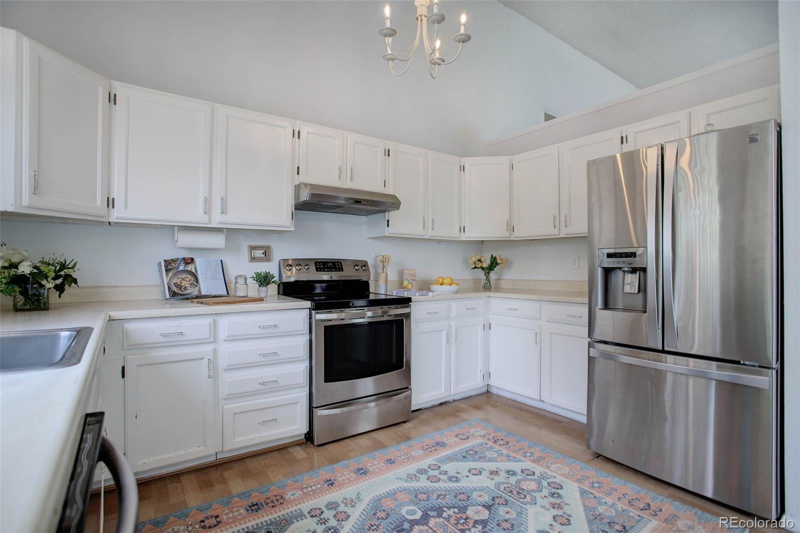 7359 Brook Forest Way Evergreen, CO 80439 - Photo 13 of 40 a kitchen with granite countertop white cabinets and stainless steel appliances
