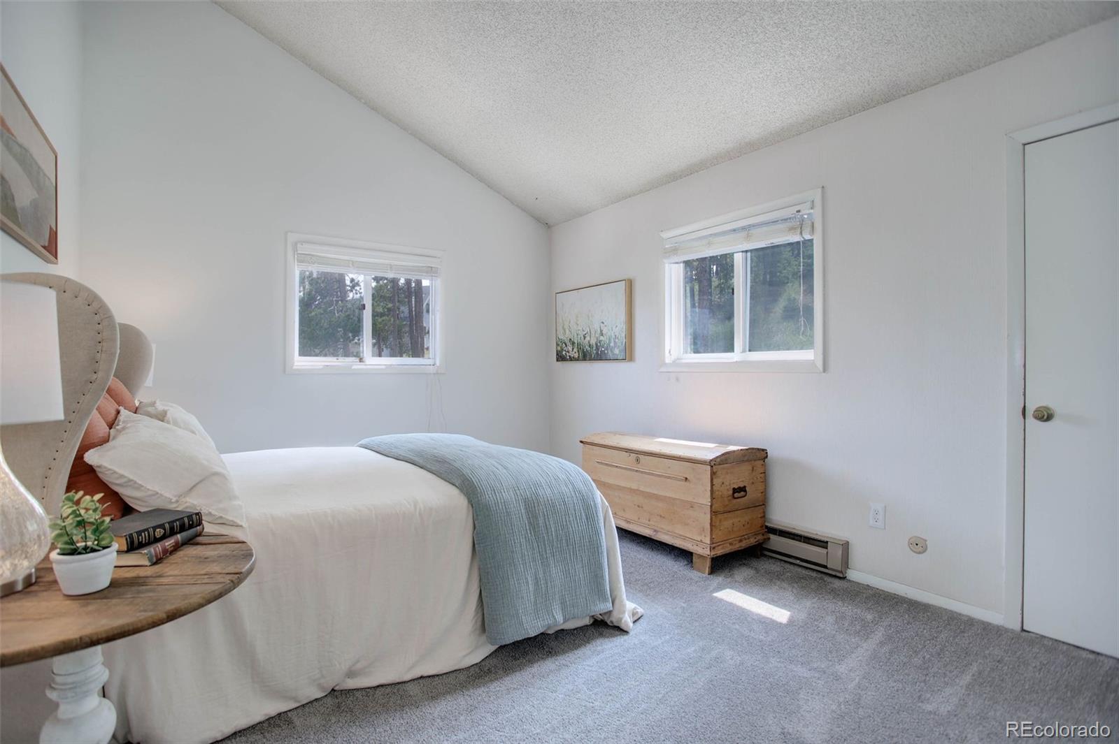 7359 Brook Forest Way Evergreen, CO 80439 - Photo 17 of 40 a bedroom with a bed and wooden floor