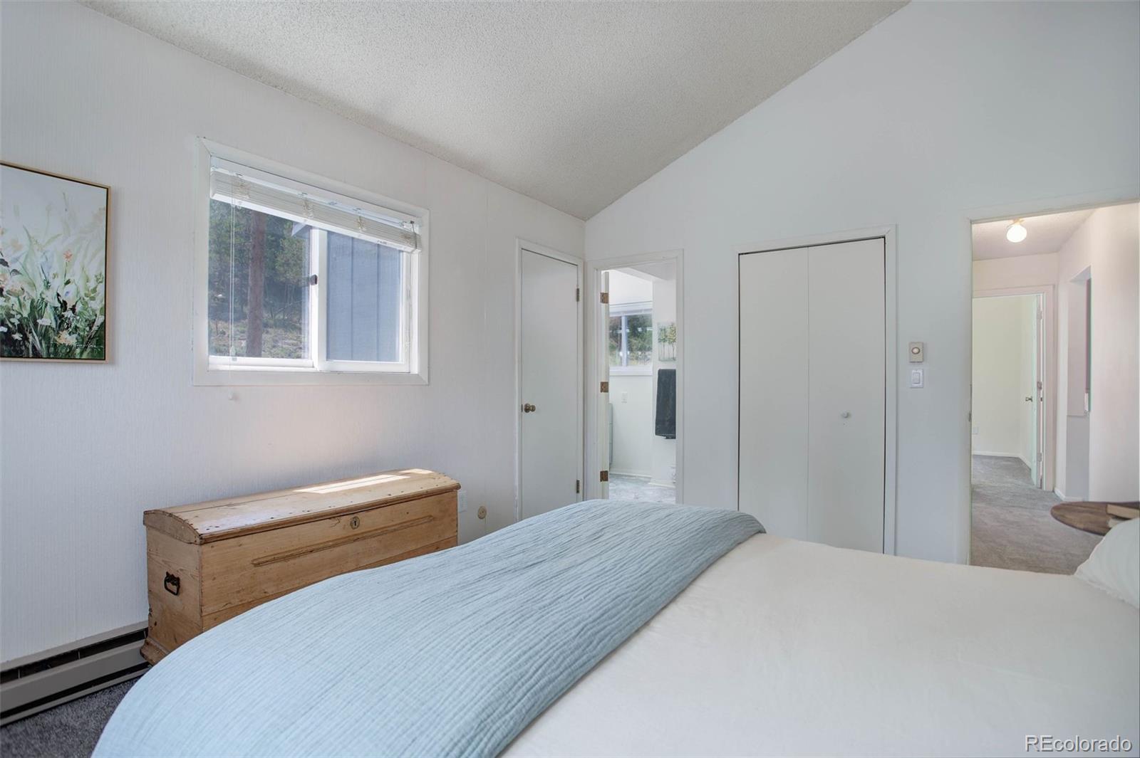 7359 Brook Forest Way Evergreen, CO 80439 - Photo 18 of 40 a bedroom with a bed and a window