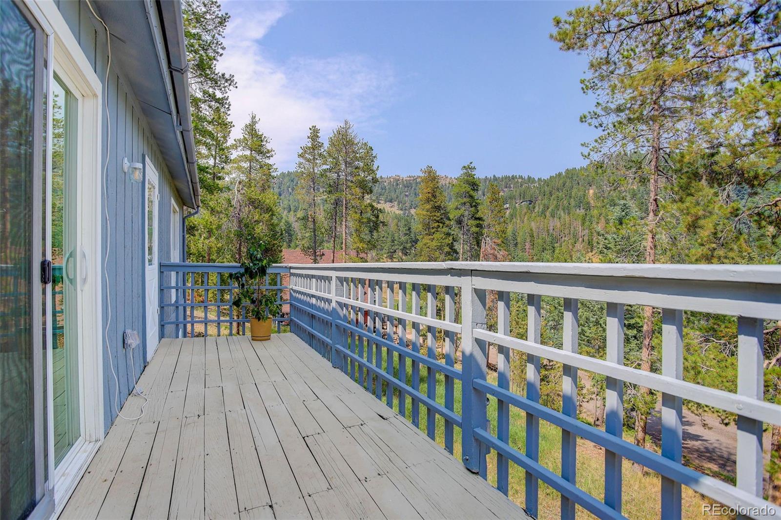 7359 Brook Forest Way Evergreen, CO 80439 - Photo 35 of 40 a view of a balcony with wooden floor and fence