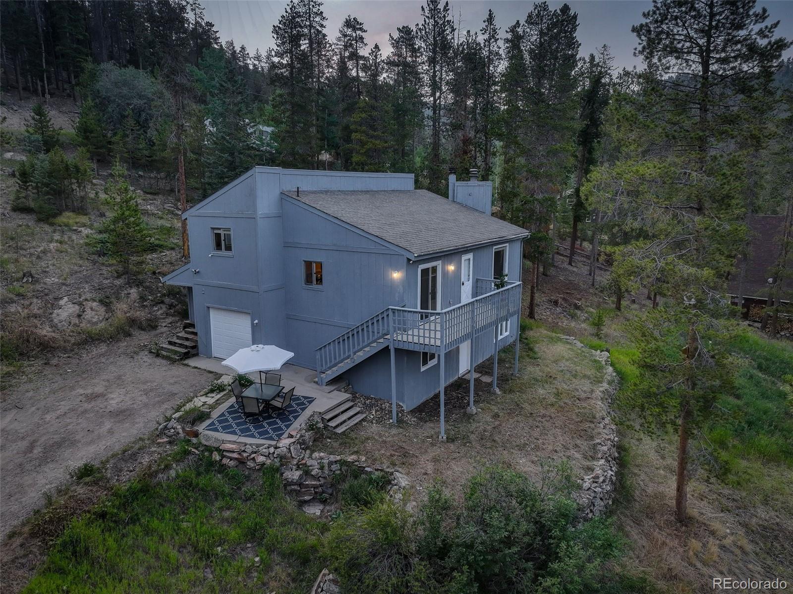 7359 Brook Forest Way Evergreen, CO 80439 - Photo 39 of 40 a backyard of a house with table and chairs
