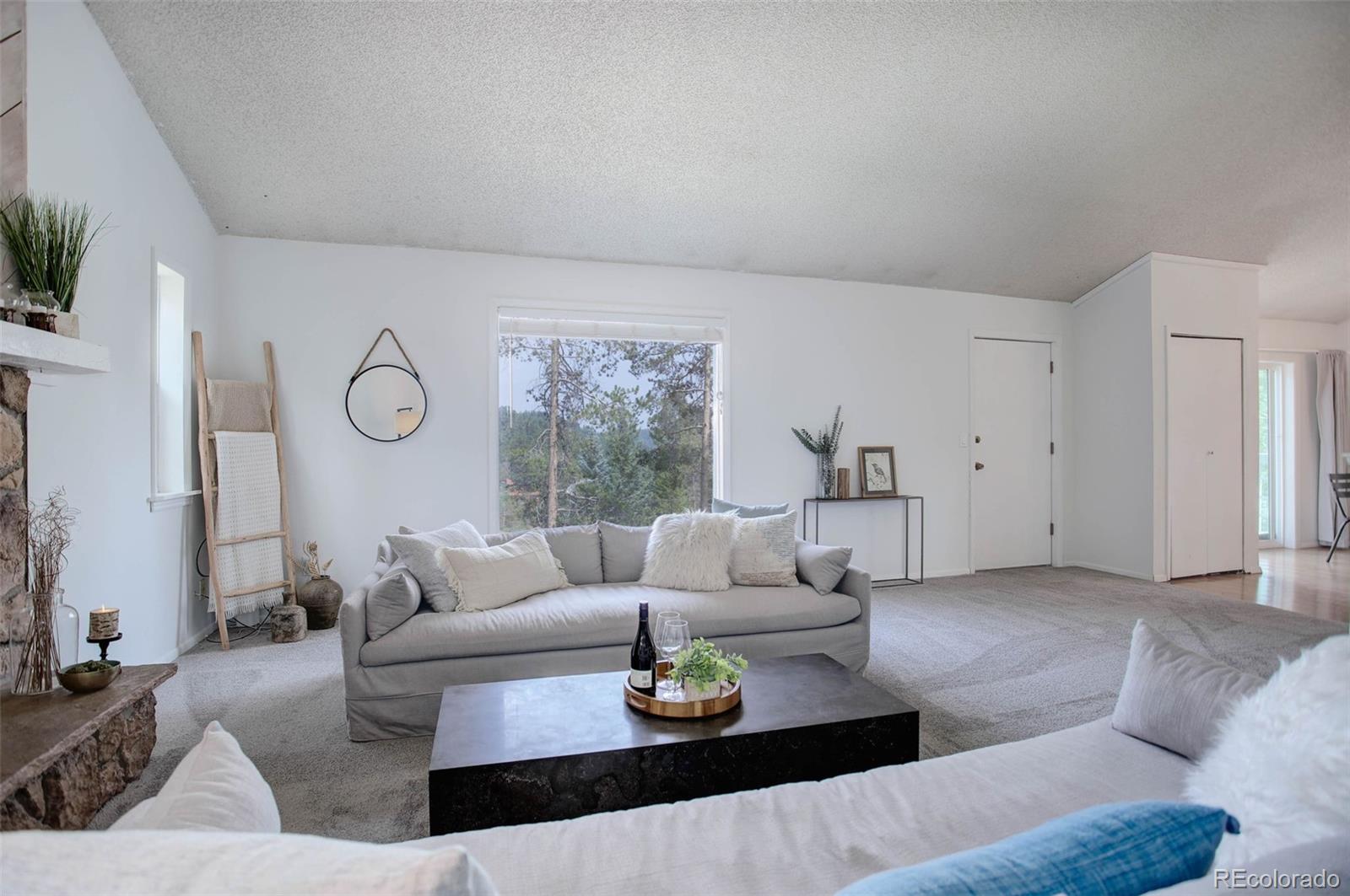7359 Brook Forest Way Evergreen, CO 80439 - Photo 7 of 40 a living room with furniture and a large window