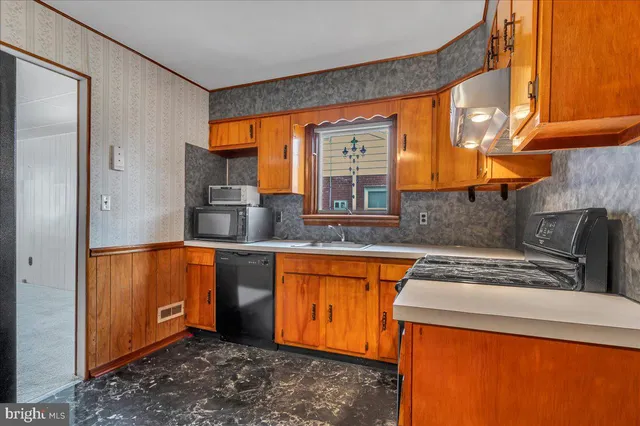 a kitchen with stainless steel appliances granite countertop a sink and a refrigerator