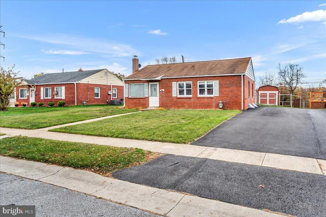 a view of a big house with a big yard and large trees