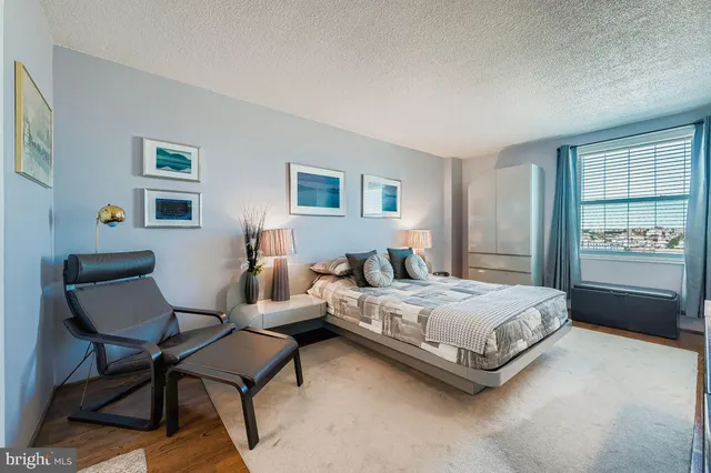 a spacious bedroom with a bed a couch and a window