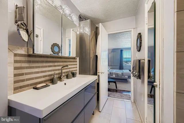 a bathroom with a sink a mirror and a shower