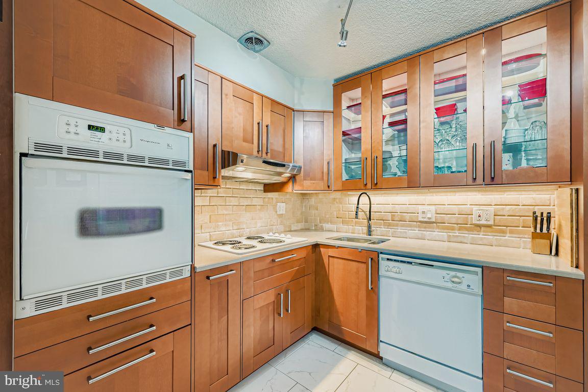 1101 St Paul Street, Unit 1410 Baltimore, MD 21202 - Photo 3 of 29 a kitchen with stainless steel appliances granite countertop white cabinets and a window