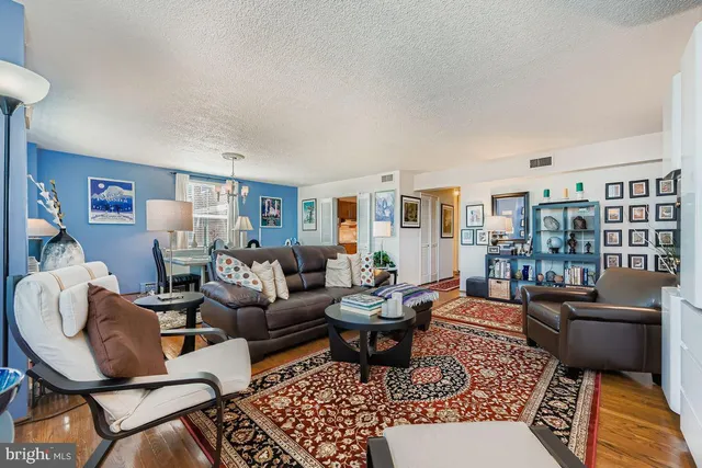 a living room with furniture a rug and a table