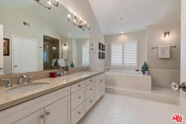a bathroom with a tub sink and mirror