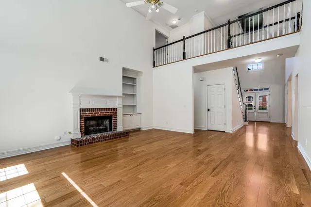 a view of empty room with wooden floor and fireplace