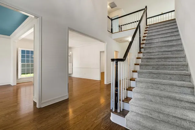 a bedroom with a large bed a chandelier and windows