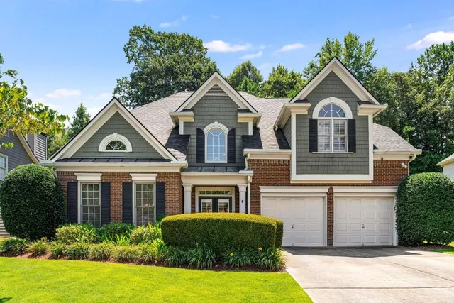 an aerial view of residential houses with outdoor space and trees