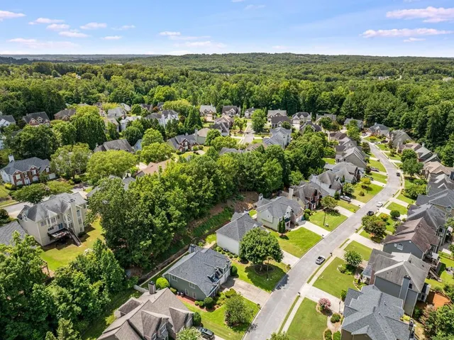 an aerial view of residential houses with outdoor space and trees