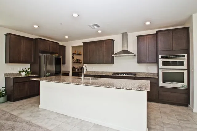 a kitchen with stainless steel appliances granite countertop a stove refrigerator and cabinets