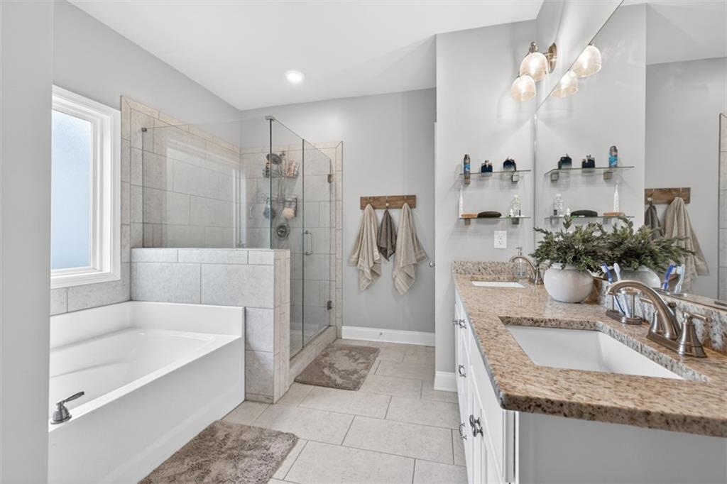 163 Hewett Road Pendergrass, GA 30567 - Photo 44 of 82 a bathroom with a granite countertop tub a sink and a large mirror