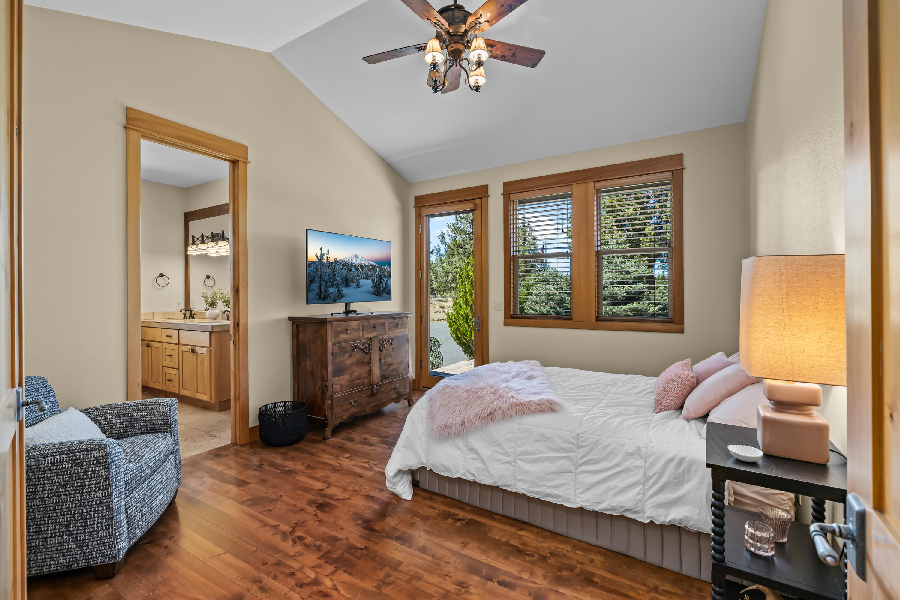 64145 Hunnell Road Bend, OR 97703 - Photo 31 of 65 Privately positioned within the guest wing, this full en-suite bedroom offers vaulted ceilings, wood flooring and direct patio access, creating a comfortable retreat for guests or extended stays.