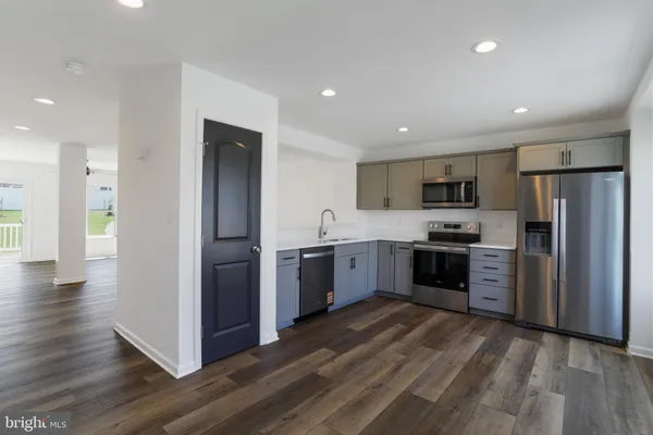 a kitchen with a refrigerator cabinets and wooden floor