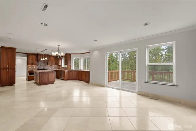 a large white kitchen with a large window and kitchen view