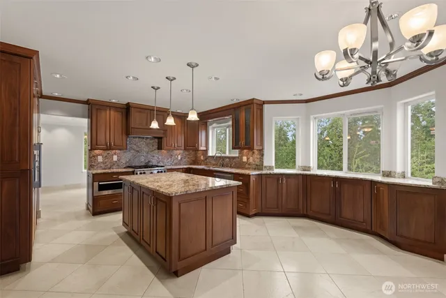 a large kitchen with kitchen island granite countertop a large center island and stainless steel appliances