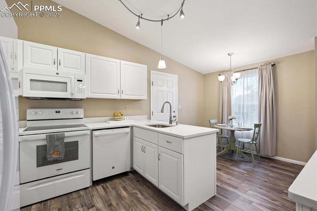704 Madison Way Bennett, CO 80102 - Photo 11 of 29 a kitchen with a sink stove and white cabinets