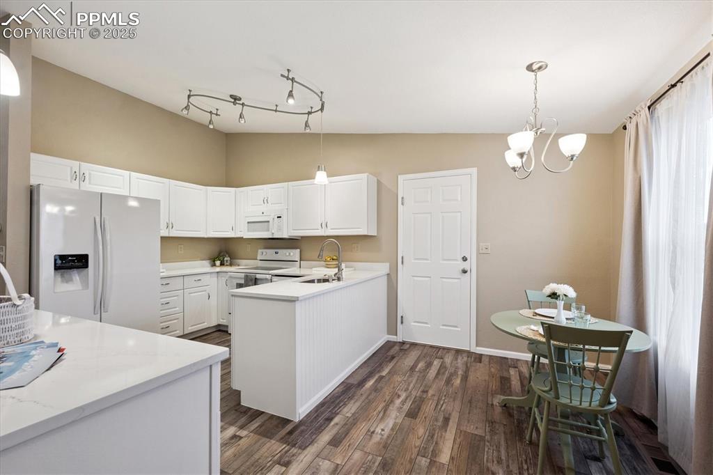 704 Madison Way Bennett, CO 80102 - Photo 9 of 29 a kitchen that has a table and chairs in it