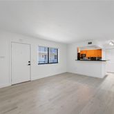 an empty room with windows and fireplace