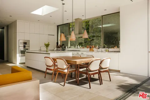 a dining room with furniture and a large window