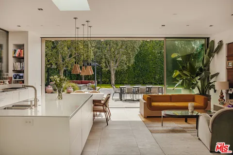 a living room with patio furniture and a floor to ceiling window
