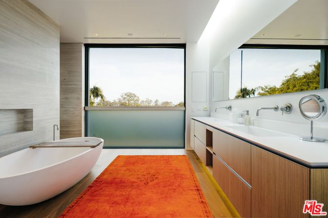 a bathroom with a tub sink and mirror