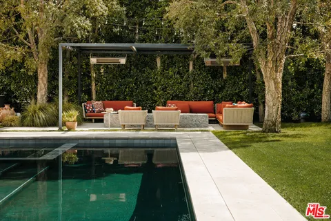 a view of swimming pool with a garden and trees