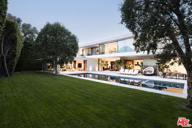 a swimming pool view with a seating space and garden view