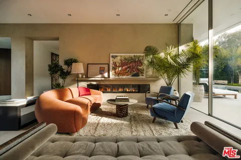 a living room with furniture a rug and a floor to ceiling window